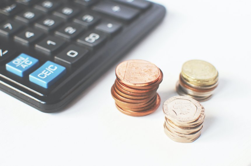 Obrazek przedstawiający kalkulator i monety- nawiązanie do kont, pod którymi można wpłacać zadłużenie, lub przekazane przez dłużnika wpłaty