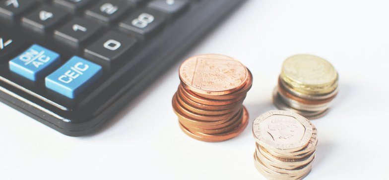 Obrazek przedstawiający kalkulator i monety- nawiązanie do kont, pod którymi można wpłacać zadłużenie, lub przekazane przez dłużnika wpłaty